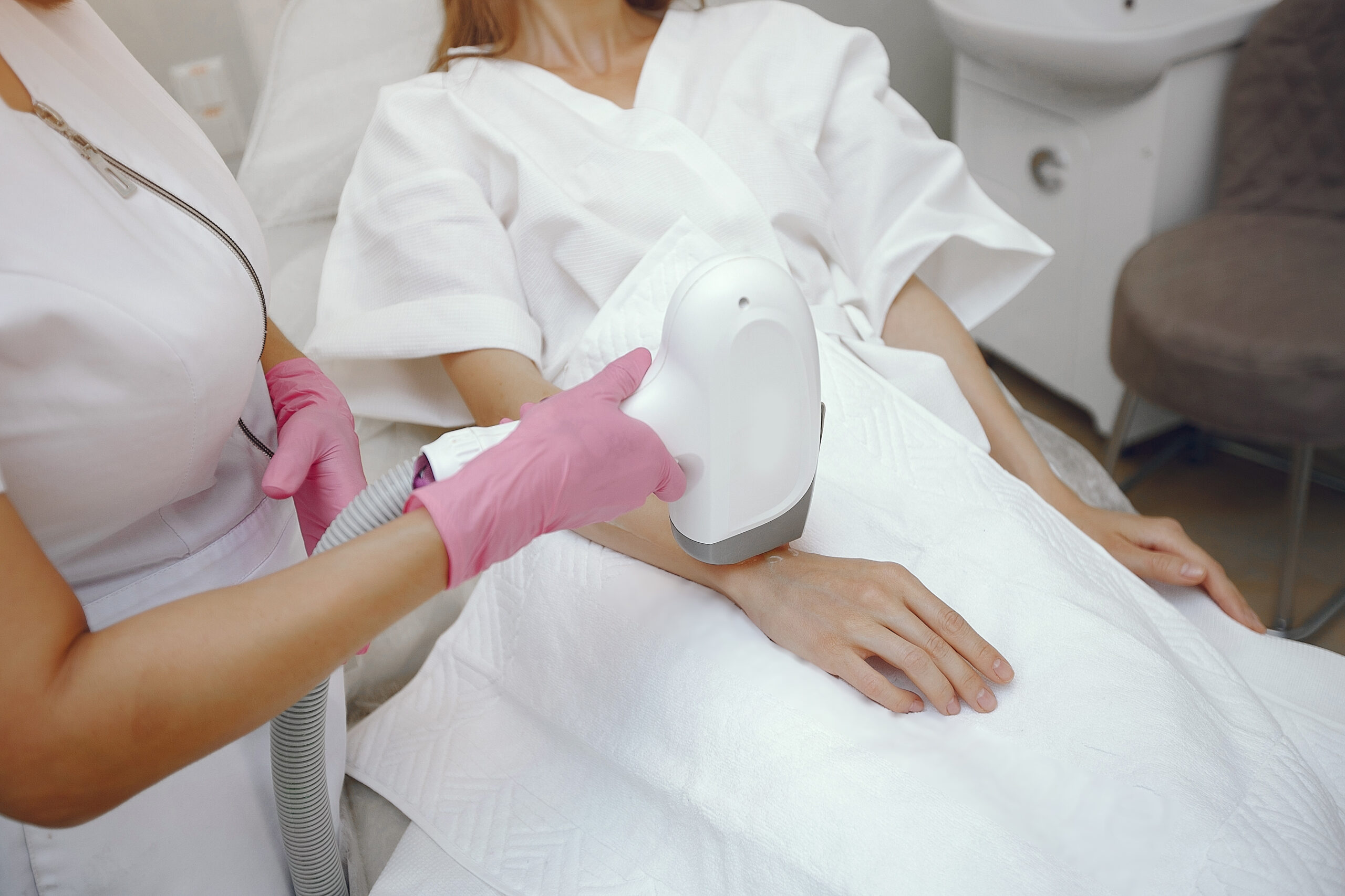 Cosmetologist use laser. Woman with cosmetologist. Lady in a beauty studio.